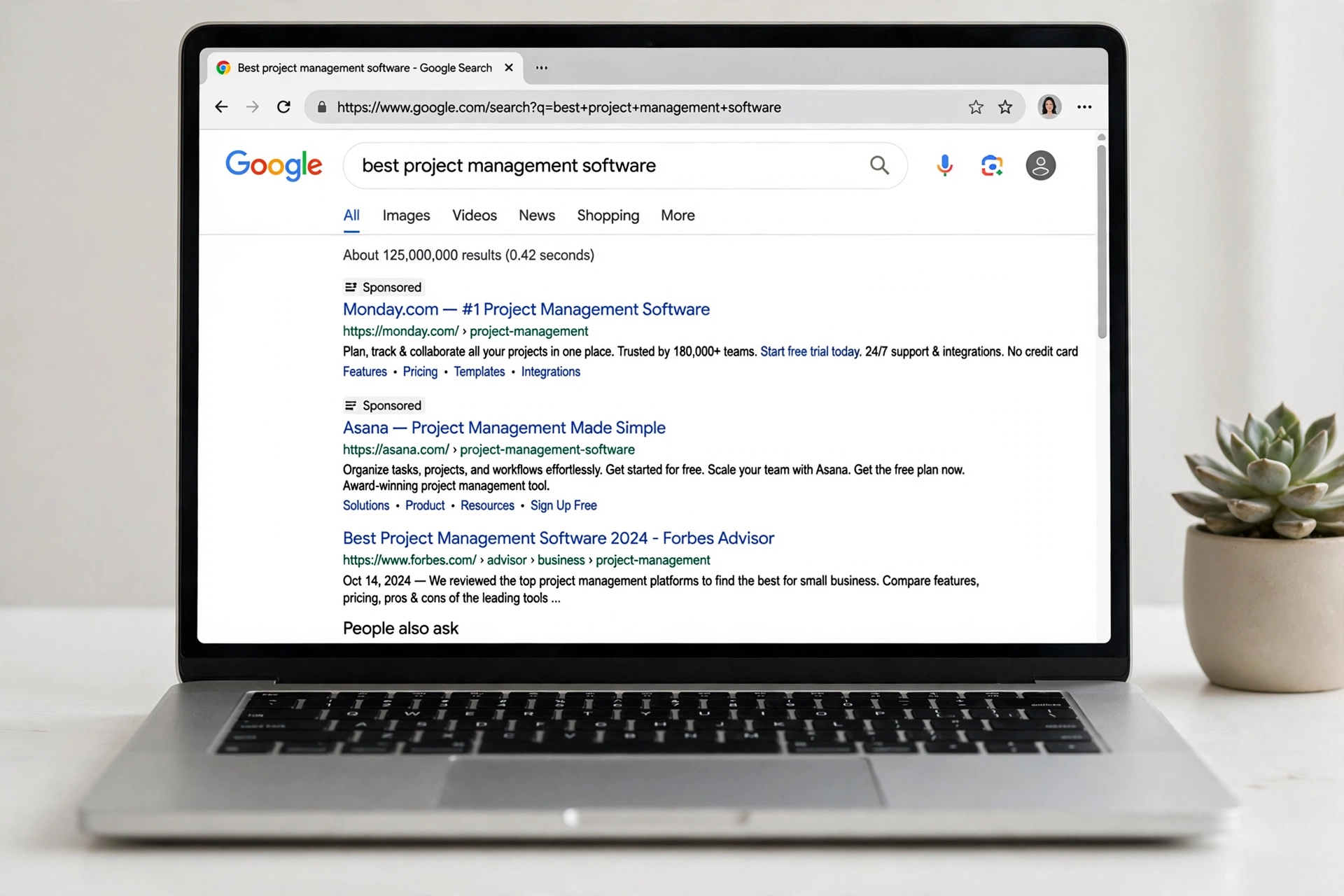 Halaman hasil pencarian Google di layar laptop dengan dua iklan bersponsor Google Ads di bagian paling atas